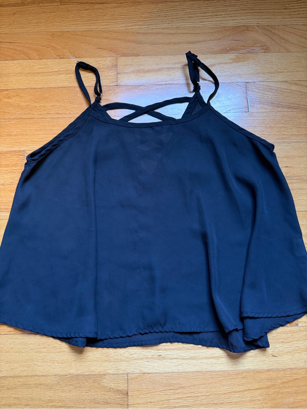 Black flowy tank top with criss cross back and adjustable straps. Size: L